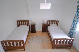 a room with two beds and two night stands at Gîte avec tennis en Baie du Mont Saint Michel à 15 minutes de la mer in Les Chambres