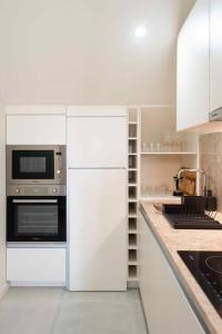 cocina blanca con armarios blancos y microondas en Pardal 2B - Penthouse Apartment in Alcantara - parking nearby en Lisboa