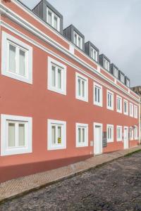 czerwony budynek z białymi oknami na ulicy w obiekcie Pardal 2B - Penthouse Apartment in Alcantara - parking nearby w Lizbonie