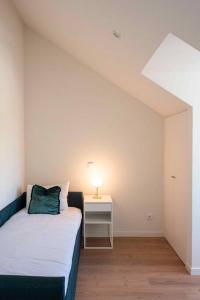 1 dormitorio con 1 cama y 1 mesa con lámpara en Pardal 2B - Penthouse Apartment in Alcantara - parking nearby en Lisboa