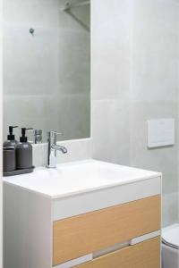 y baño con lavabo blanco y espejo. en Pardal 2B - Penthouse Apartment in Alcantara - parking nearby en Lisboa