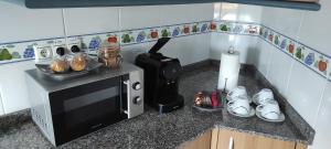 a small kitchen with a microwave and a stove at Piso As Rodas in Villanueva de Arosa +11 photos