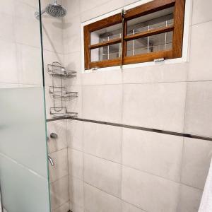 a shower with a glass door in a bathroom at Casa turismo Mendoza in Godoy Cruz