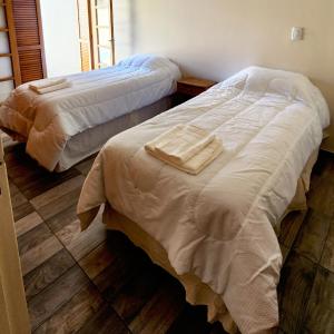 two beds in a bedroom with towels on them at Casa turismo Mendoza in Godoy Cruz