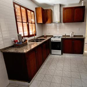 a kitchen with wooden cabinets and a stove top oven at Casa turismo Mendoza in Godoy Cruz