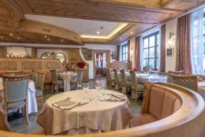 a dining room with tables and chairs and windows at Park Hotel Sport in Andalo