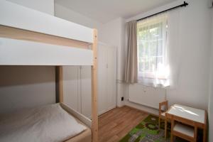 een slaapkamer met een stapelbed, een bureau en een raam bij Black Hill Apartments in Lauterwasser