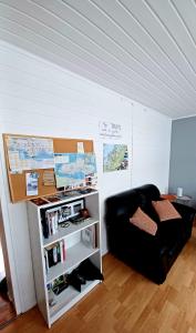 a living room with a black couch and a book shelf at Tromso Coco Apartments in Center in Tromsø