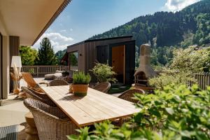 a patio with a wooden table and chairs at CHILL HOUSE in Schladming