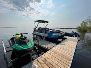 two boats are docked at a dock on the water at Auberge Lac St-Jean Phase 2 in Roberval