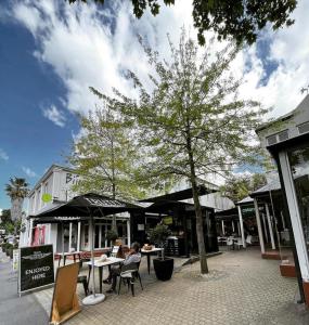 a woman sitting at a table in front of a tree at Franschhoek Studio in Franschhoek