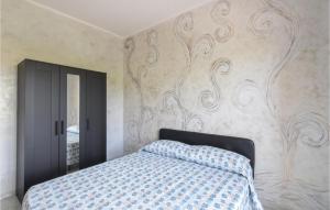 sypialnia z łóżkiem i ścianą z malowidłem w obiekcie Nice Apartment In Tronca With 2 Bedrooms And Wifi w mieście Marina di Strongoli