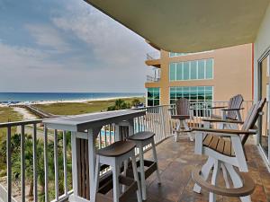 a balcony with a table and chairs and the beach at Tidewater orange Beach 209 in Orange Beach