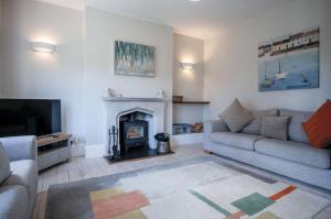 a living room with a couch and a fireplace at Penlan - 3 Bedroom Cottage - Saundersfoot in Saundersfoot