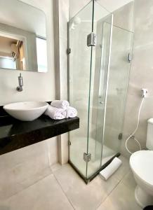 uma casa de banho com um lavatório e uma cabina de duche em vidro. em Dublê Hotel - The Original no Recife