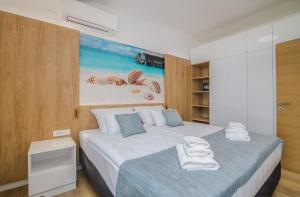a bedroom with two beds with towels on them at Apartment Marko in Malinska