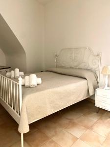 ein Schlafzimmer mit einem weißen Bett mit weißen Kissen in der Unterkunft Angolo nella Roccia in Ostuni