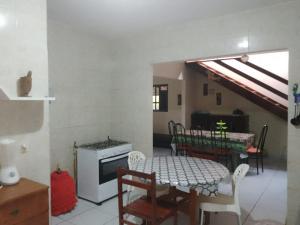 a kitchen and dining room with a table and a stove at Chácara da Bel in Pitimbu