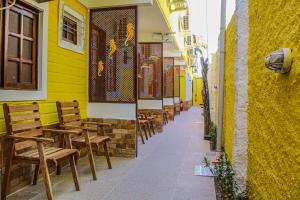 a street with chairs and a yellow building at Pousada Farol do Porto Nova ADM 2026 in Porto De Galinhas