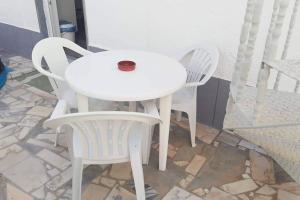 2 sillas blancas y una mesa y sillas blancas en Moradia V2, Manta Rota, 700m da Praia, en Vila Nova de Cacela