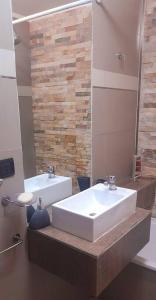 łazienka z 2 umywalkami i lustrem w obiekcie Moderno departamento w mieście Godoy Cruz