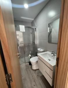 La salle de bains est pourvue de toilettes, d'un lavabo et d'une douche. dans l'établissement We Are Hostel 2, à Póvoa de Varzim