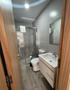 a bathroom with a toilet and a sink and a shower at We Are Hostel 2 in Póvoa de Varzim