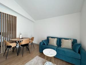 - un salon avec un canapé bleu et une table dans l'établissement Apartments Johnny, à Podstrana