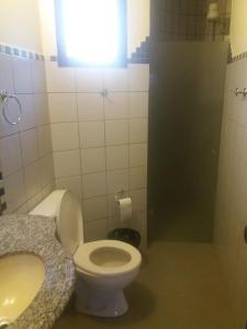 a bathroom with a white toilet and a sink at Recanto das Águas in Rio Quente