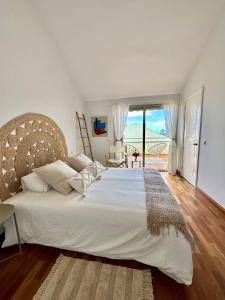 a bedroom with a large white bed with a large window at 3 bedroom house in Pasito Blanco port, 5 min walk to the beach in Pasito Blanco