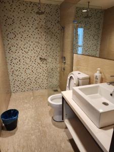 ein Bad mit einem Waschbecken, einem WC und einer Dusche in der Unterkunft Regalia Suites KL Infinity Pool _ by MygeHomes in Kuala Lumpur