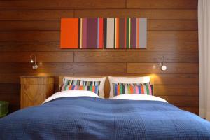 1 dormitorio con 1 cama azul y paredes de madera en Haus Astrid, en Kitzbühel