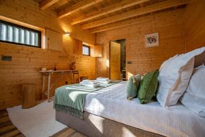- une chambre avec un lit dans une cabane en bois dans l'établissement Villa Prendal Eco Living - Minho's Guest, à Guimarães