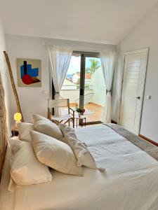 a large white bed with pillows in a bedroom at 3 bedroom house in Pasito Blanco port, 5 min walk to the beach in Pasito Blanco