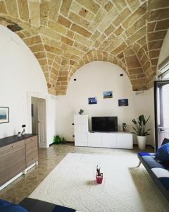 a living room with a couch and a tv on a wall at Casa Vacanze Momò a Nardò in Nardò