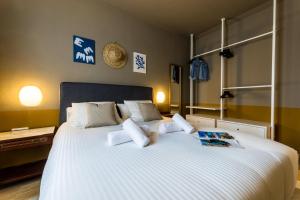ONDARRA Suite Apartment في سان سيباستيان: غرفة نوم بسرير ابيض كبير مع مخدات بيضاء