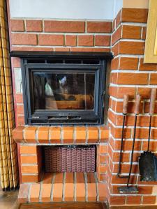 a brick fireplace with a television in it at Dom na Zaciszu in Koniaków