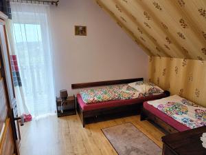a bedroom with two beds and a window at Dom na Zaciszu in Koniaków