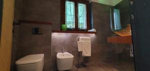 baño con aseo y lavabo y ventana en Casa vacanze Tredis, en Nogaredo di Prato