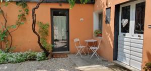 a patio with two chairs and a table in front of a building at Casa vacanze Tredis in Nogaredo di Prato