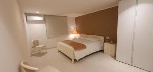 1 dormitorio pequeño con 1 cama y 1 silla en Casa vacanze Tredis, en Nogaredo di Prato