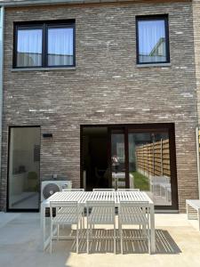 a white table and chairs in front of a brick building at Chez Victorine Kortrijk in Kortrijk