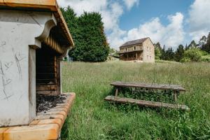 an old building and a bench in a field at Casa Berbesa in Castropol