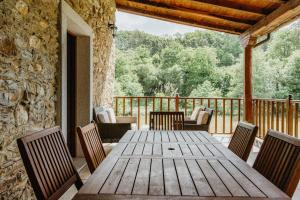 a wooden table and chairs on a deck at Casa Berbesa - Caserío en Asturias 3, Jardín, BBQ, FAM in Castropol +44 photos
