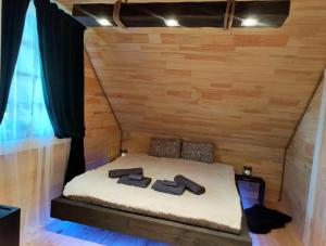 a bed in a wooden room with two pairs of shoes at Provinces Idille in Gulbene