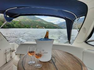 una mesa con dos copas de vino en un barco en Douro - Noite a Bordo, en Tabuaço