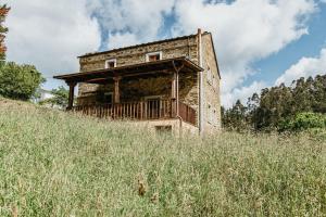 an old stone house on a hill with a balcony at Casa Berbesa in Castropol