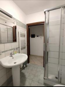 een badkamer met een witte wastafel en een douche bij Dimora San Martino in Offida