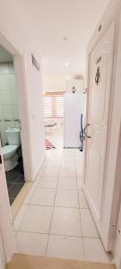uma casa de banho com piso em azulejo branco e uma porta em Best Home City 1 em Alanya