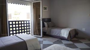 a bedroom with two beds and a sliding glass door at riad casa bahia asilah in Asilah